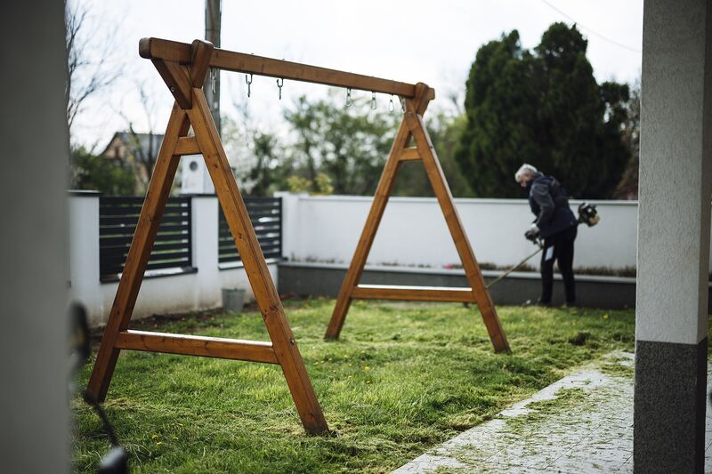 A-frame wooden swing set frame in a freshly mowed backyard