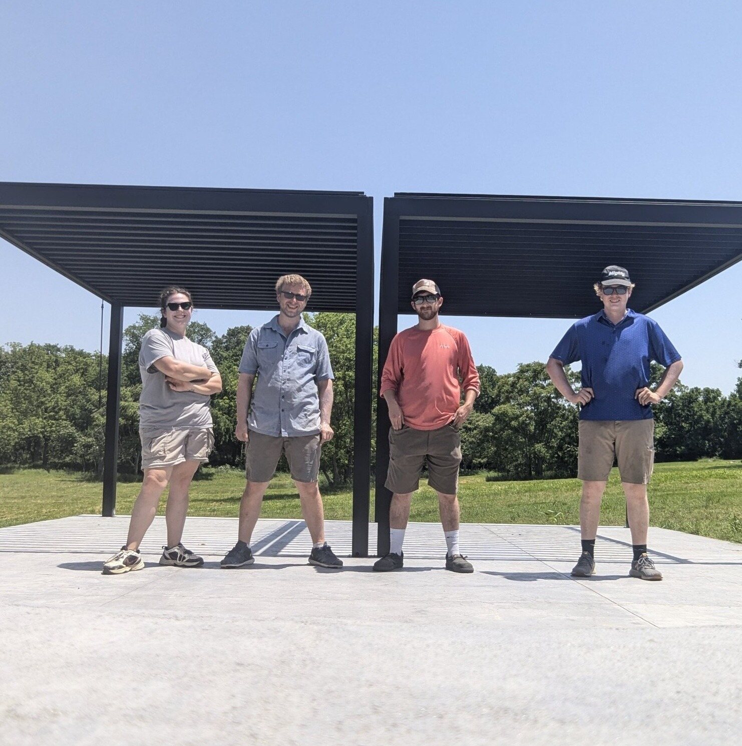 The four-person NWA Assembly crew, including Chad Sitze, standing in front of two recently installed pavilions